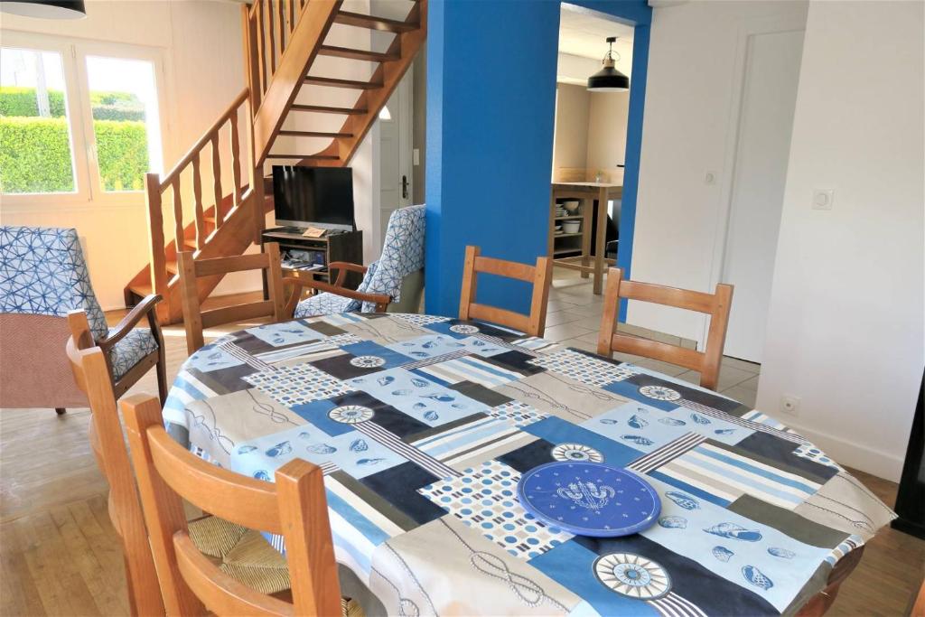 stół jadalny z niebiesko-białym blatem w obiekcie Maison avec jardin, WIFI, à 50m de la plage à TREGASTEL - Réf 195 w mieście Trégastel