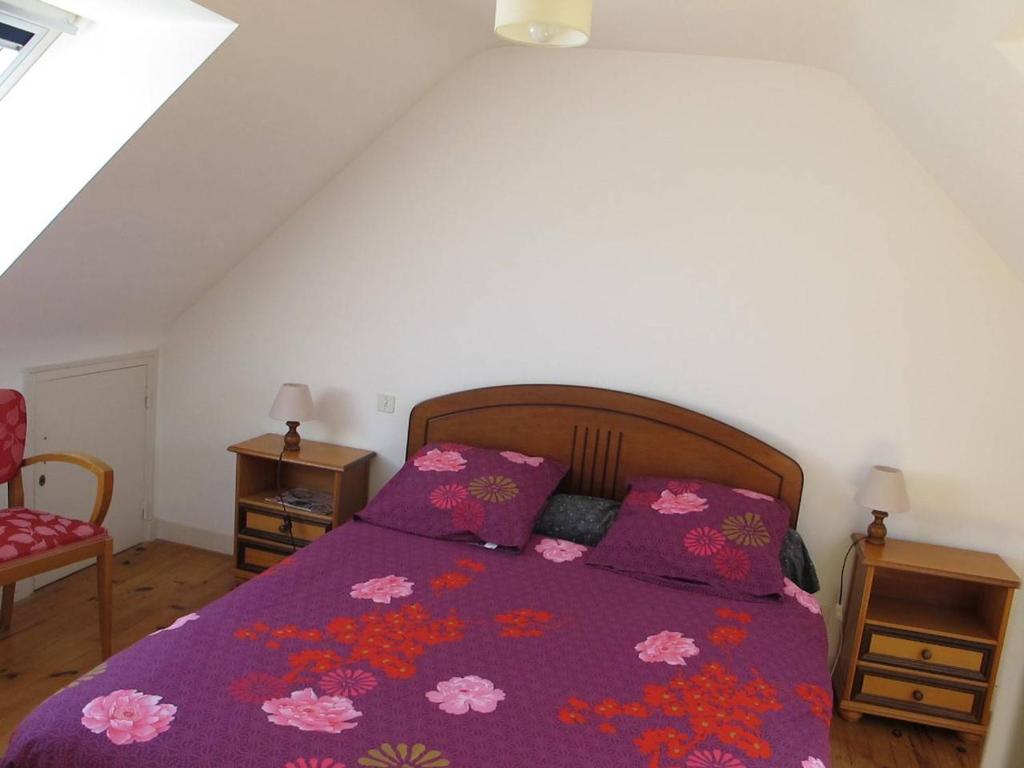 sypialnia z łóżkiem z fioletową kołdrą w obiekcie Maison avec jardin, WIFI, à 50m de la plage à TREGASTEL - Réf 195 w mieście Trégastel