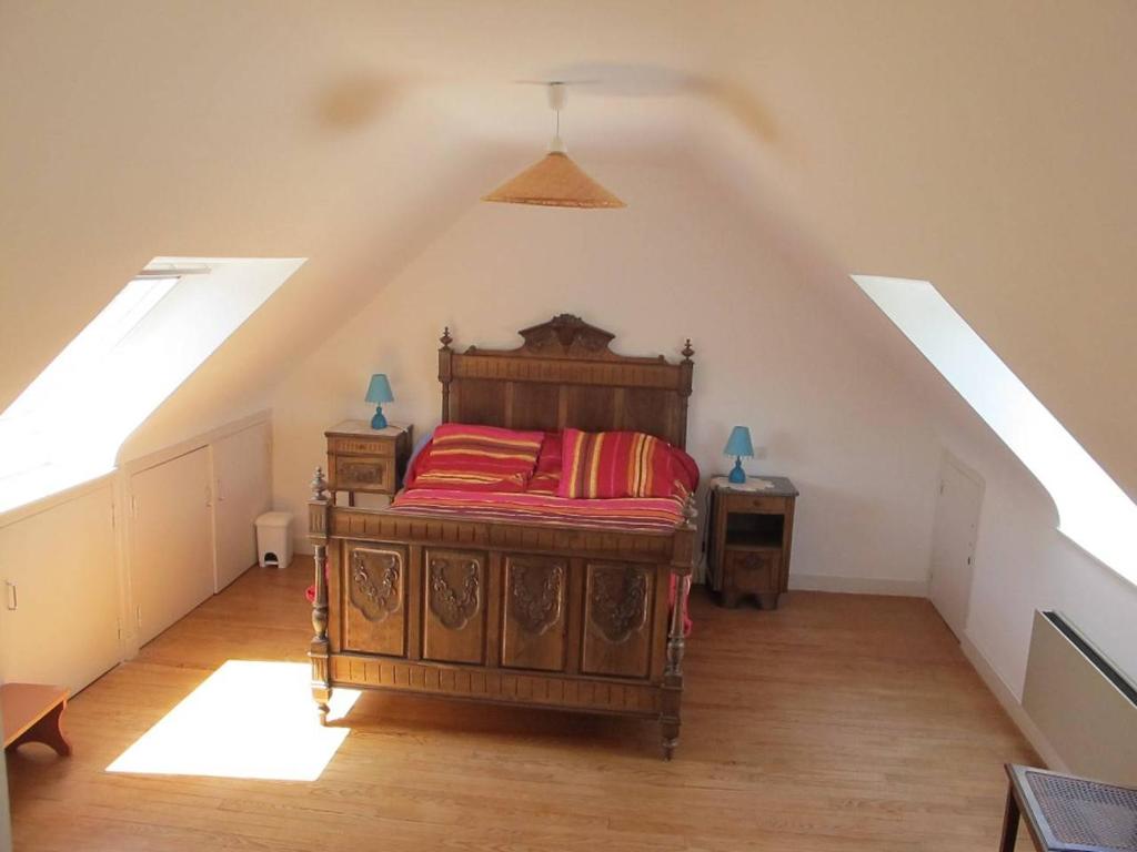 sypialnia z drewnianym łóżkiem na poddaszu w obiekcie Maison avec jardin, WIFI, à 50m de la plage à TREGASTEL - Réf 195 w mieście Trégastel