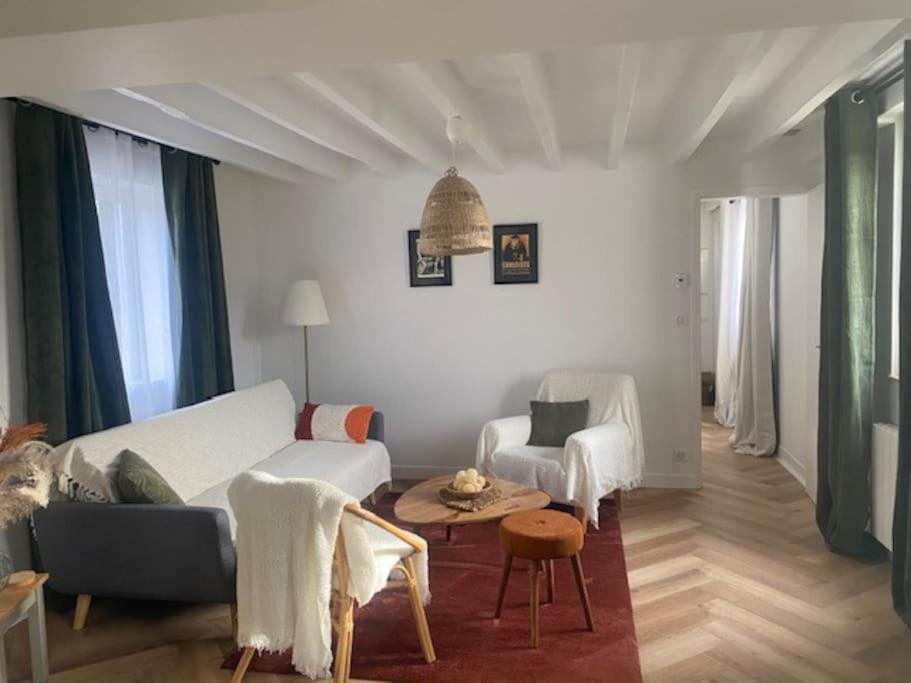 un soggiorno con divano bianco e tavolo di YVECRIQUE - Maison avec Jardin tout confort 2 à 6 pers 