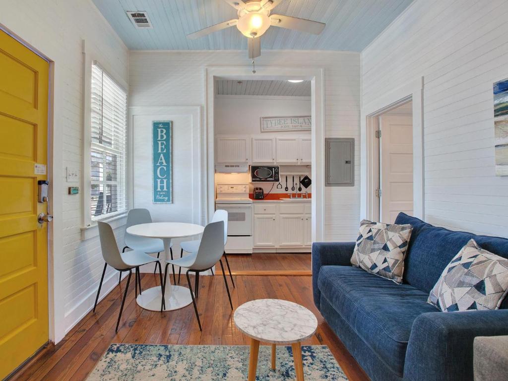 een woonkamer met een blauwe bank en een tafel bij Beach Walk 4 in Tybee Island
