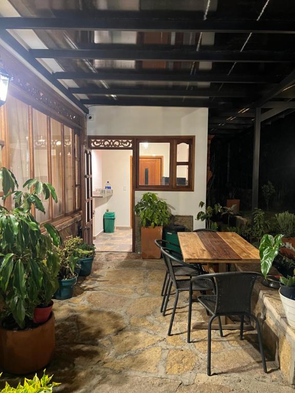 une chambre avec une table, des chaises et des plantes en pot dans l'établissement Cabaña Ensueño, à Villa de Leyva