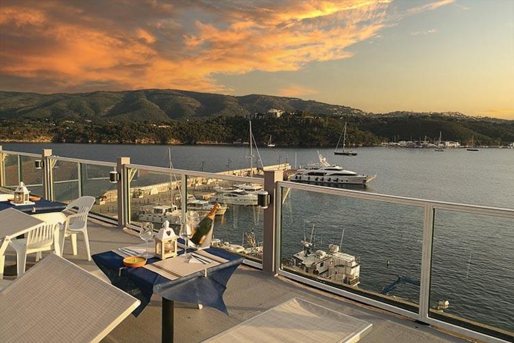 a balcony with tables and chairs on a boat in the water at Hotel Belmare in Porto Azzurro