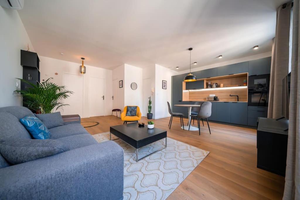 un salon avec un canapé bleu et une table dans l'établissement L'Hédoniste, Elégant T2, Clim, Centre Ville, à Montpellier