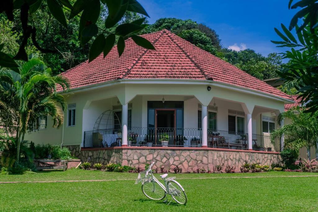 a house with a bike parked in the grass at The Greenleaf Luxury BnB -Lubowa in Kampala