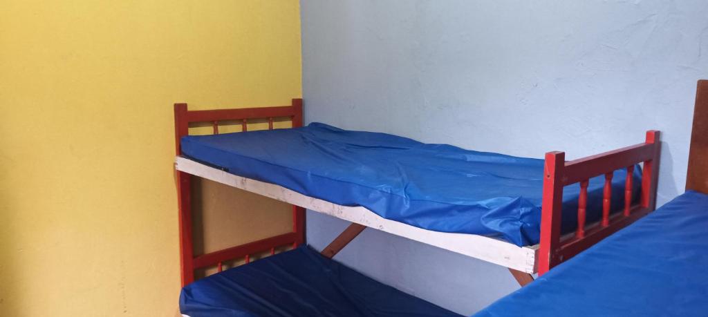 SolemarにあるCasa para temporada baixada santistaの二段ベッド2組(ブルーシーツ付)が備わる客室です。