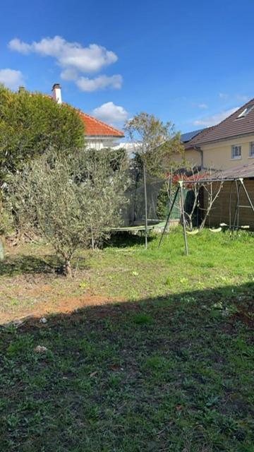 une cour avec une maison et une balançoire dans l'établissement L’amazone, à Sannois