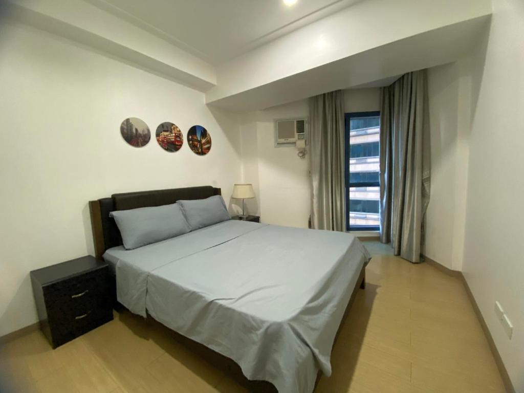 um quarto com uma cama grande e uma janela em SnugglePod Condotel - Grand Riviera Suites, US Embassy Manila, Roxas Blvd em Manila