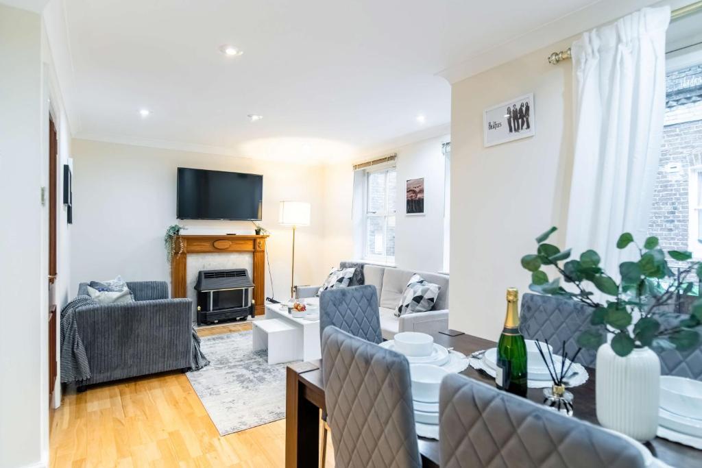 a living room with a couch and a table with chairs at Livestay-Chic 3-Bed Mews Townhouse in St John's Wood in London