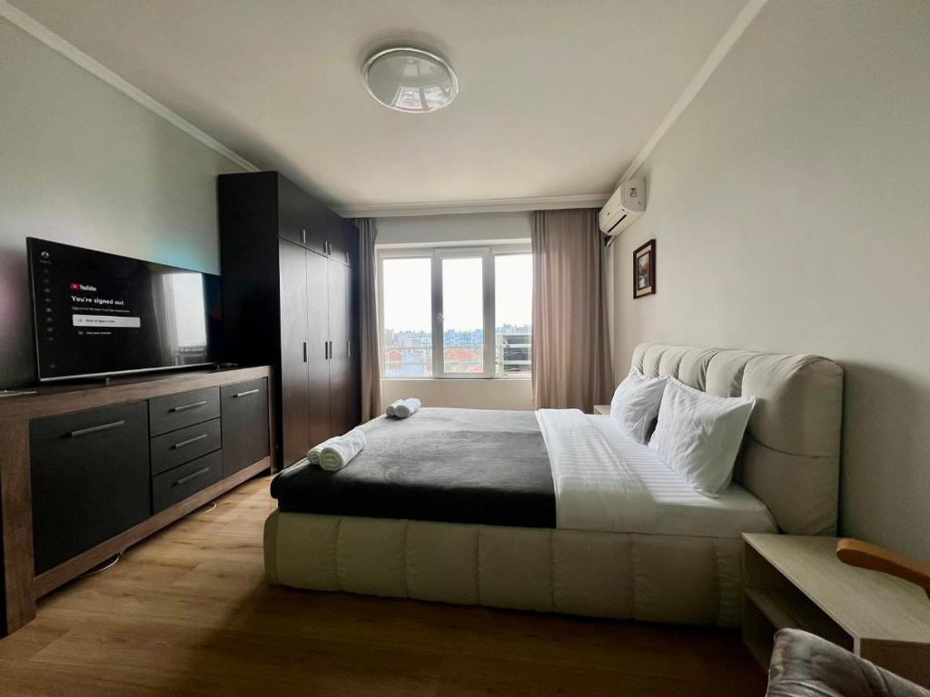1 dormitorio con 1 cama y TV de pantalla plana en Amazing view central 1 bedroom apartment en Pazardzhik