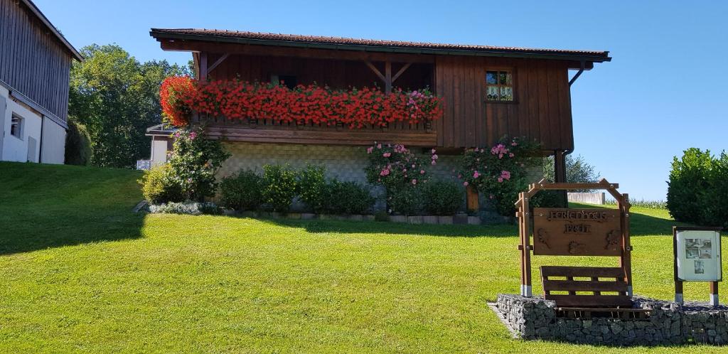 a sign in front of a house with flowers at Ferienhaus Breit in Eppenschlag