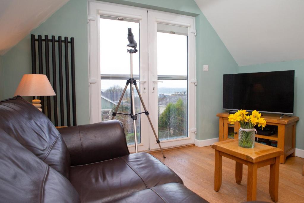 a living room with a couch and a television at Vilureef Broad Haven in Broad Haven