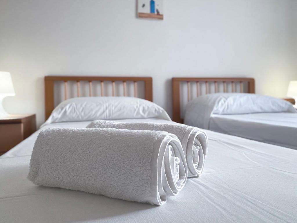 Zwei Handtücher liegen auf zwei Betten. in der Unterkunft Villa Dino in Foce Varano