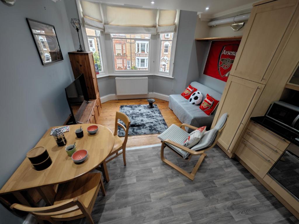 un soggiorno con tavolo, sedie e divano di LOVELY 1 BEDROOM FLAT IN FINSBURY PARK/EMIRATES STADIUM a Londra