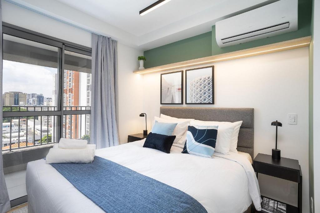 a bedroom with a large bed and a large window at 360 My Moema in São Paulo