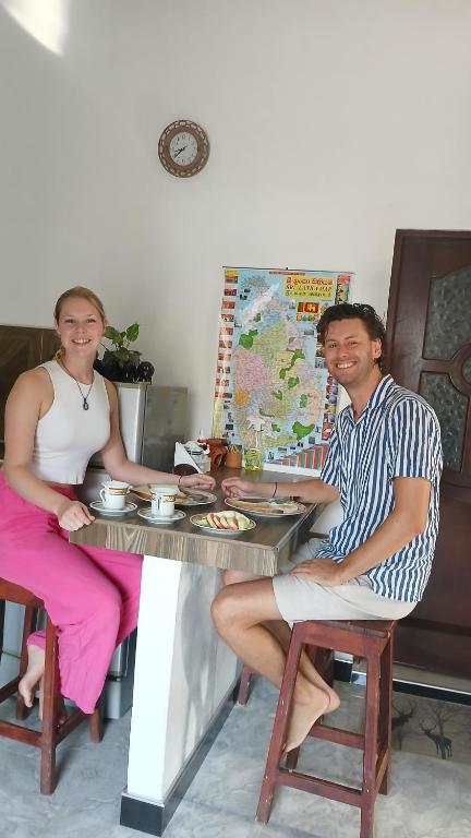een man en een vrouw aan een tafel bij Aloe Vera villa in Negombo