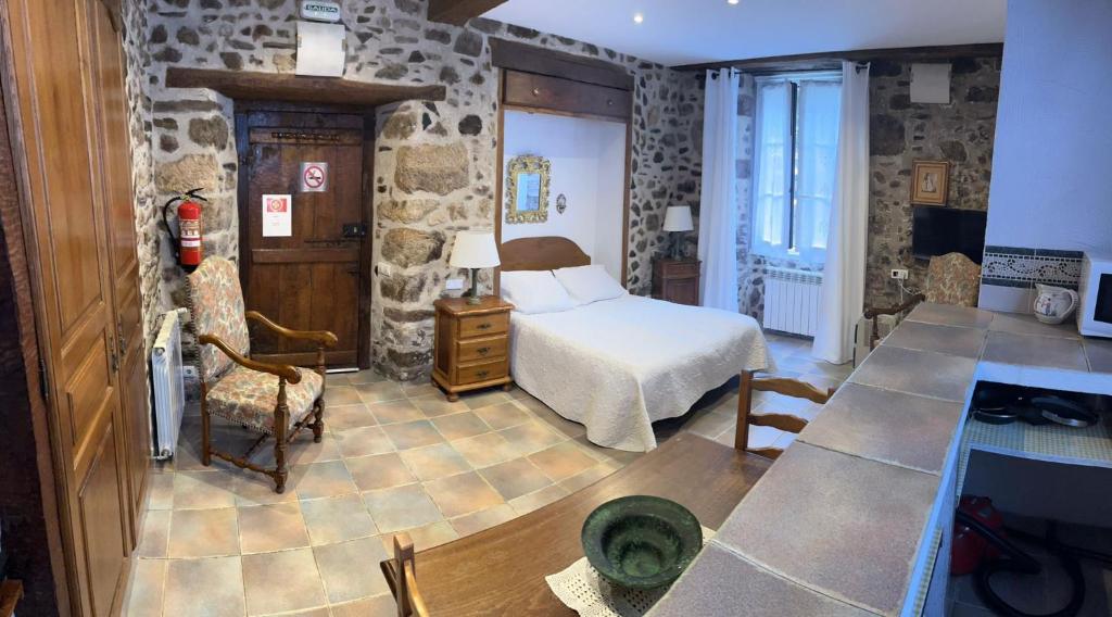 a bedroom with a bed and a table in a room at Etxezuria in Valcarlos