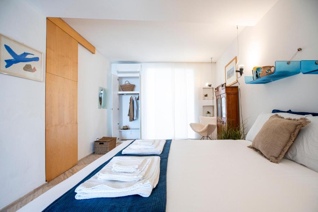 a bedroom with a large white bed with blue accents at La Casetta sul mare in Castellammare del Golfo