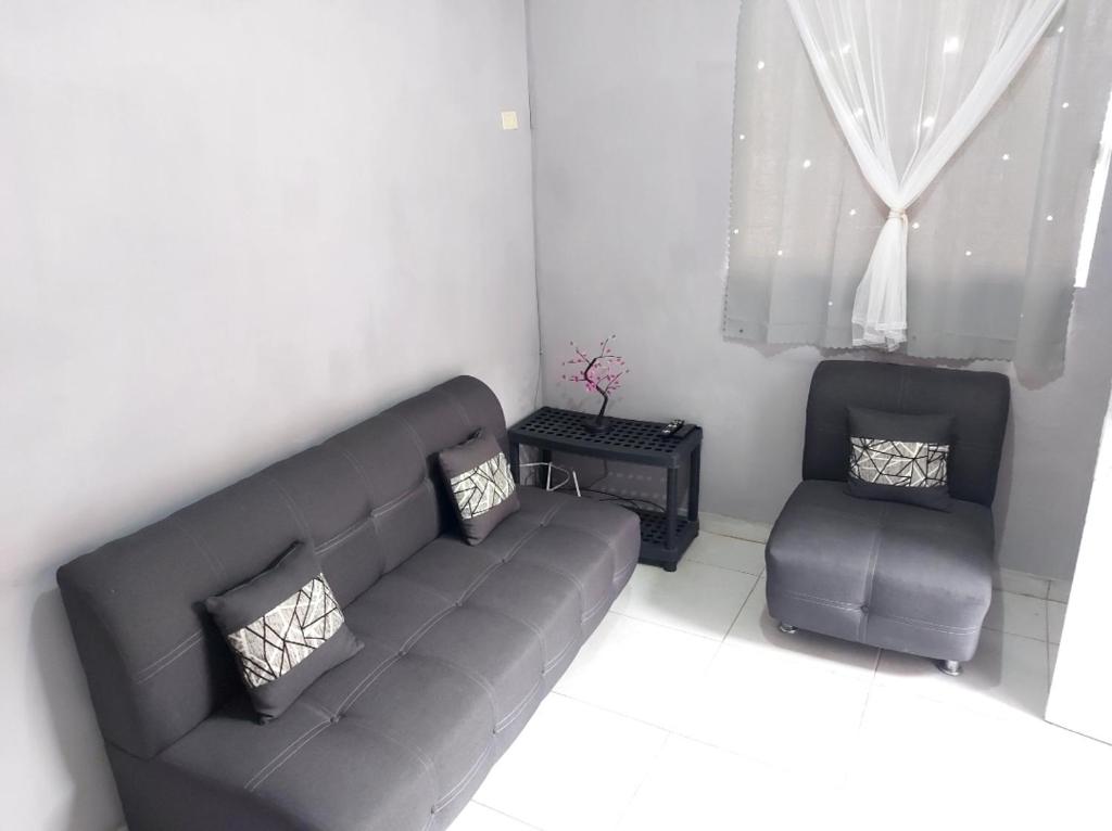 uma sala de estar com um sofá e uma cadeira em Residencia El Encanto em Mazatlán