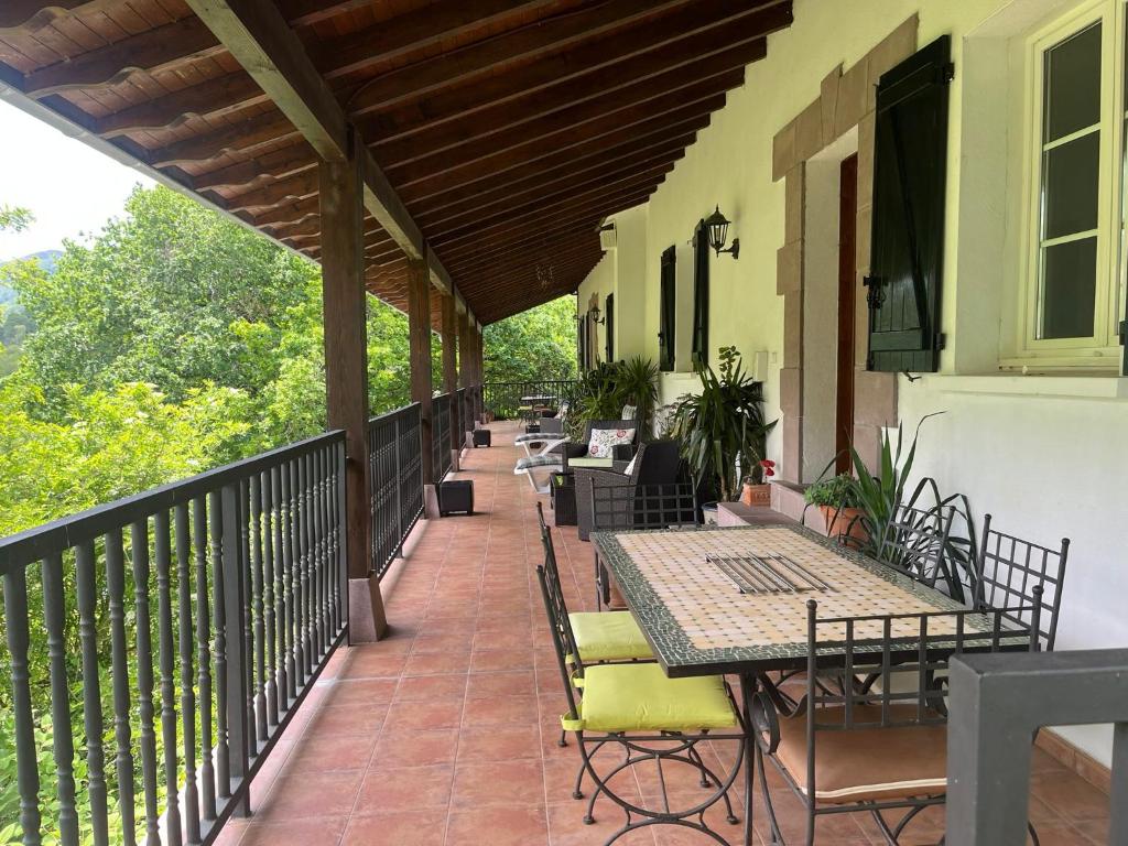 eine Terrasse mit Tischen und Stühlen auf dem Balkon in der Unterkunft Etxezurialde ll in Valcarlos
