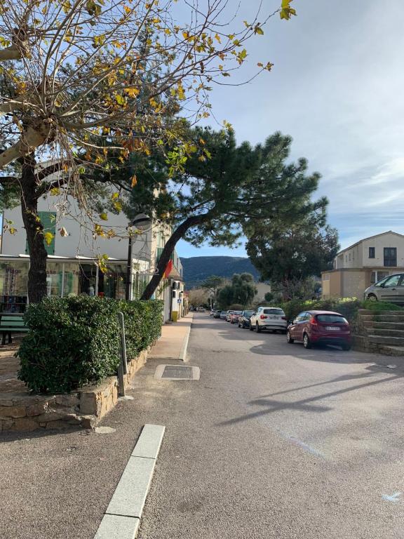 une rue avec des voitures garées sur le bord de la route dans l'établissement 3p, grd terrasse, jardin, centre-ville, 150m de la mer, à Algajola