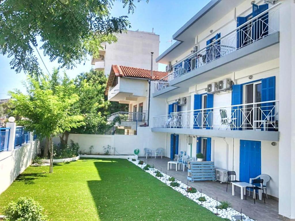 an apartment with a lawn in front of a building at Sea Breeze 201 in Skála Neón Epivatón