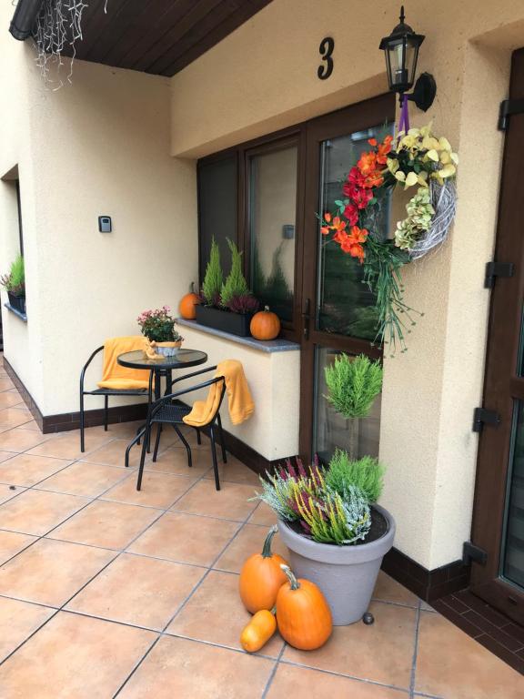 a patio with a table and chairs and pumpkins at Spadzista 3 in Kłodzko