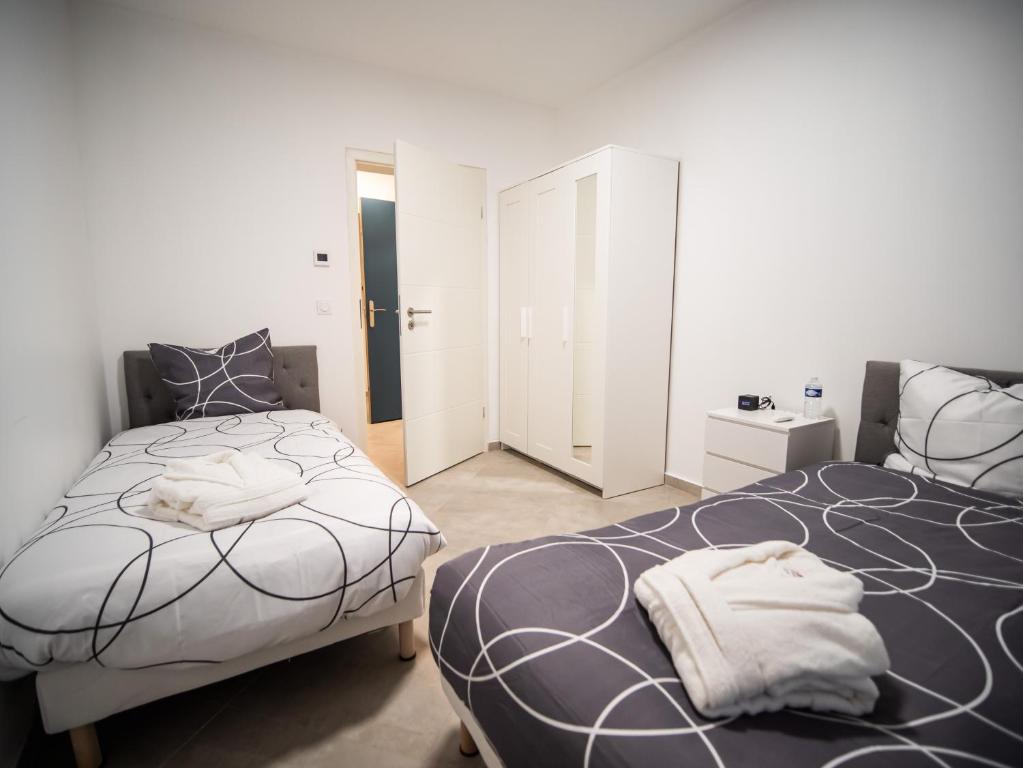 une chambre avec deux lits et un miroir dans l'établissement Adalia lodge, à Yutz