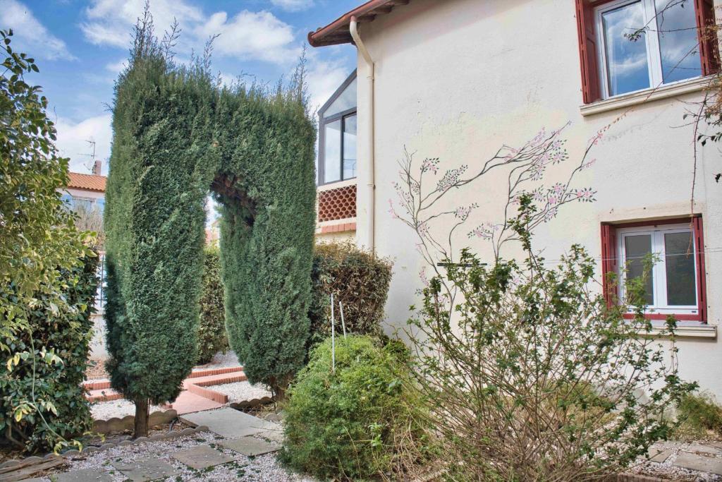 a house with an ivy covered doorway into a yard at Quiet and bright nest near Perpignan in Pia