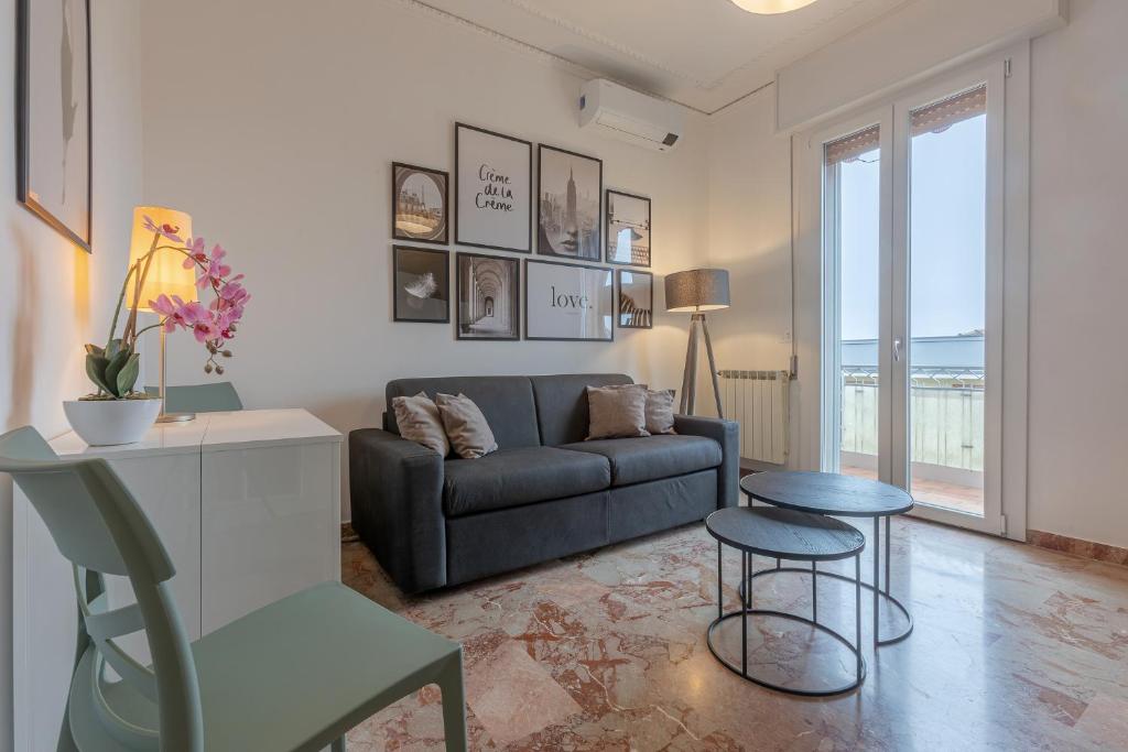 uma sala de estar com um sofá, uma mesa e um banco em Ferrara Il Castello Dazzling Apartment em Ferrara