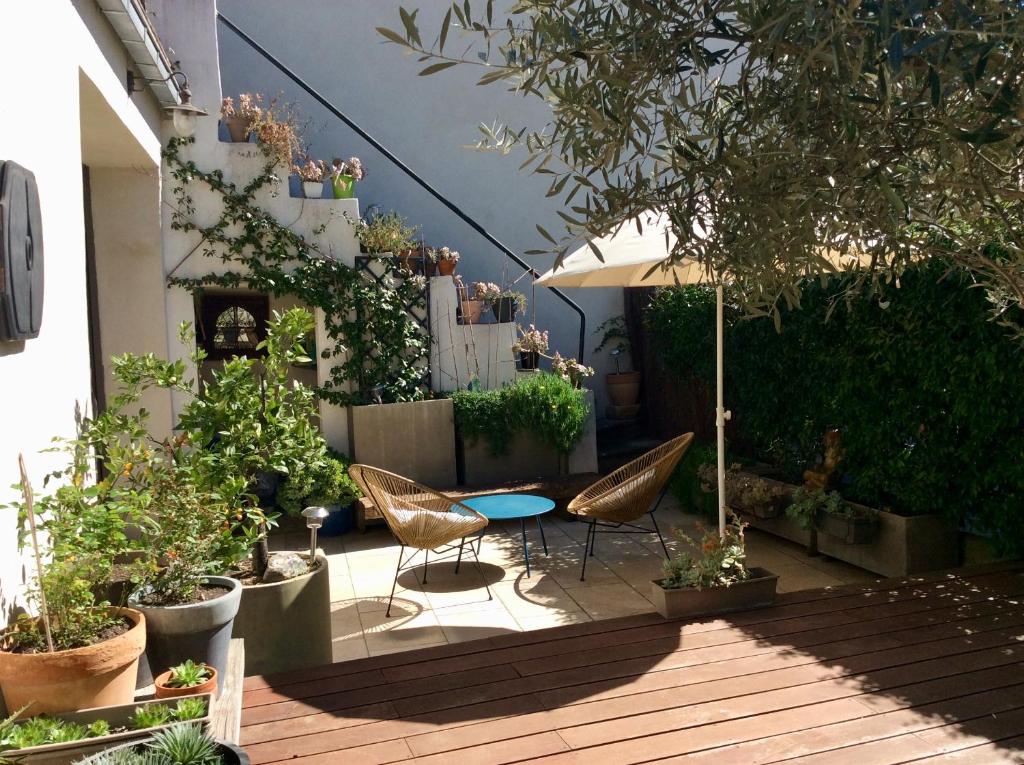 un patio avec une table, des chaises et des plantes dans l'établissement Maison de ville entre amis ou en famille, à Castelnau-le-Lez