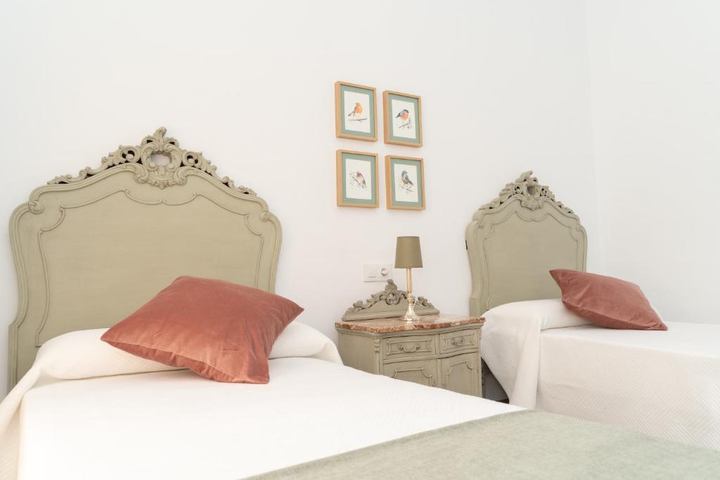 una camera con due letti e un comodino con due specchi di Casa Palacio Vida a Espejo