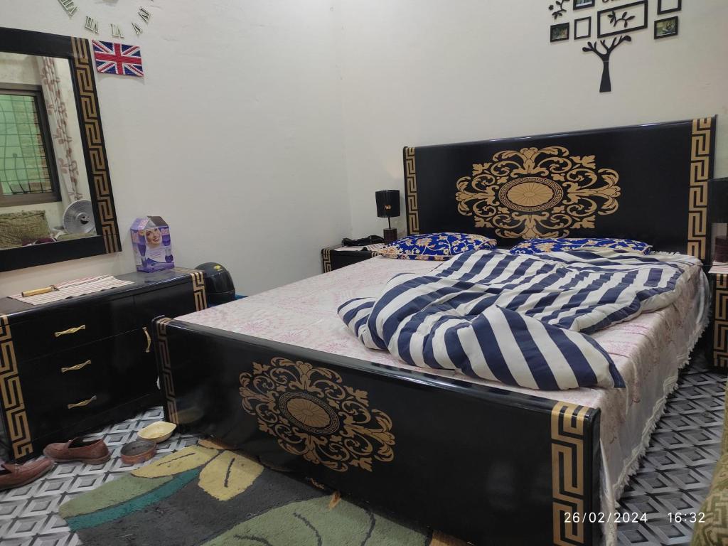 Muslim friendly guest house في سيالكوت: غرفة نوم بسرير كبير وخزانة