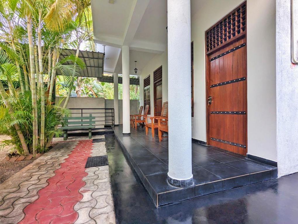 a front door of a house with a red carpet at Golden Pearl Safari Villa in Udawalawe