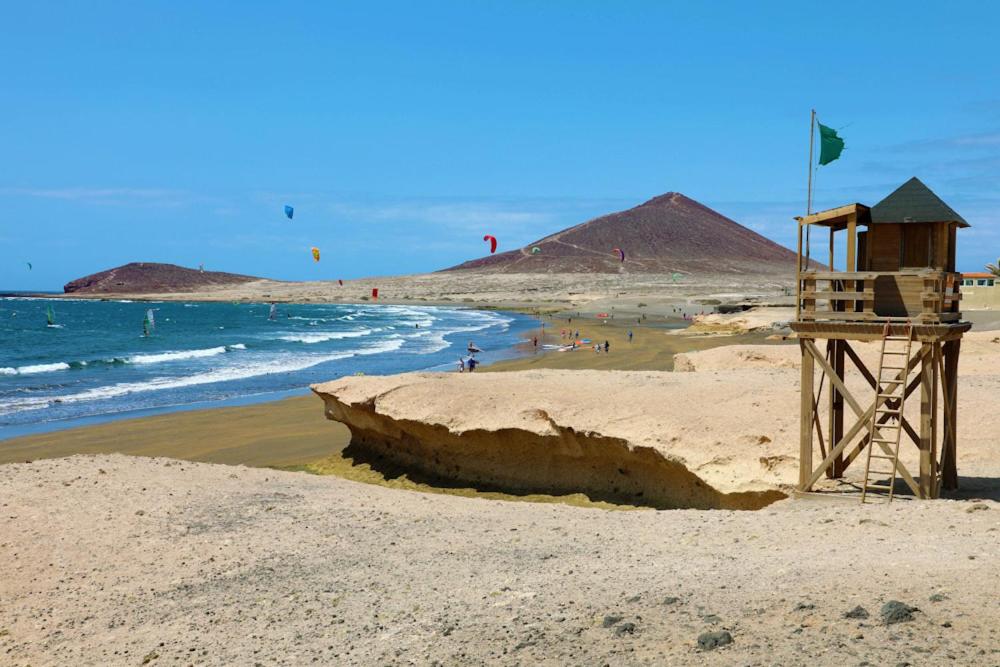 a beach with people flying kites in the ocean at Casa Canaria shared house in El Médano