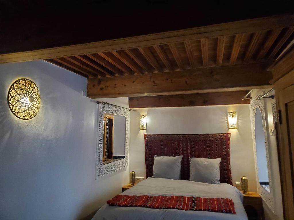een slaapkamer met een bed en een houten plafond bij Riad Averroès in Fès