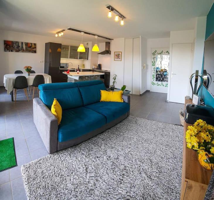 un salon avec un canapé bleu et une cuisine dans l'établissement Le Mont Royal, à La Ciotat