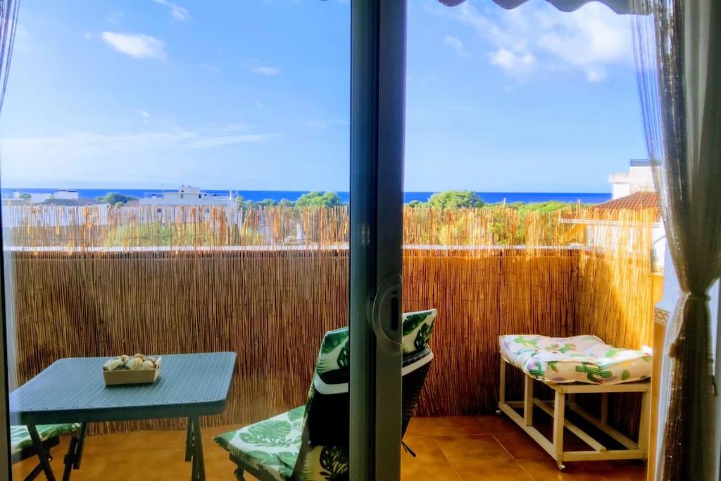 a view of a balcony with a table and a window at ¡Espectacular apto con vistas al mar con Wifi! in Comarruga