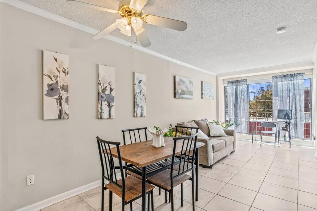 a living room with a ceiling fan and a table and chairs at Downtown Columbia Apartment in Columbia