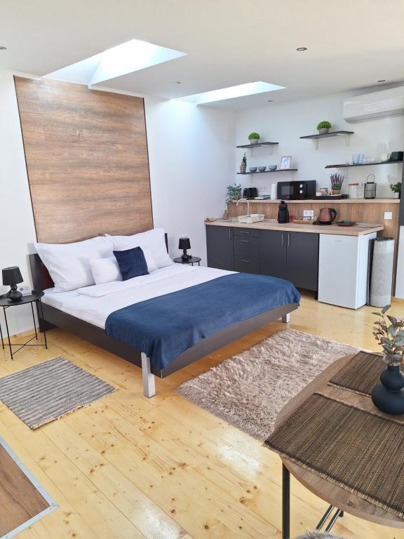 a bedroom with a large bed and a kitchen at Várfal apartman II in Eger
