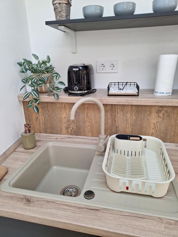 a kitchen sink with a dish drying rack next to it at Várfal apartman II in Eger