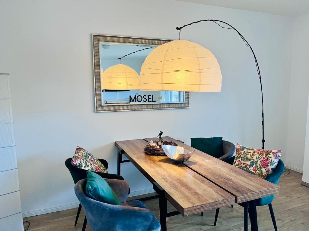una sala da pranzo con tavolo in legno e sedie blu di Mosel Quartier 32 a Brodenbach