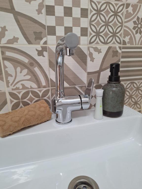 a bathroom sink with a faucet on a sink at Várfal apartman II in Eger