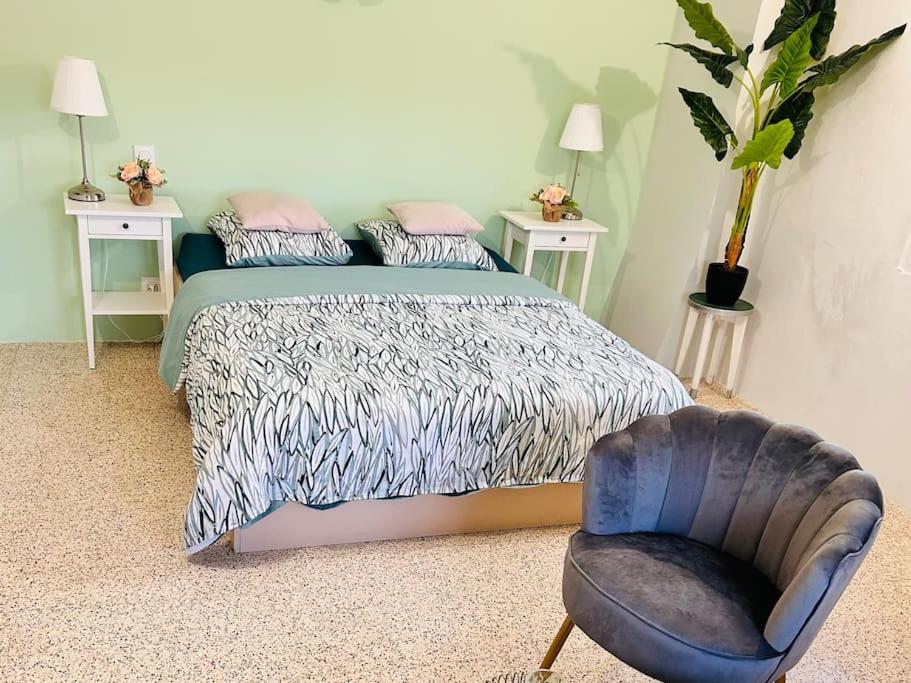 une chambre avec un lit et une chaise bleue dans l'établissement Les logis de la Combette appartement 2 personnes, à Saint-Rémy-de-Provence