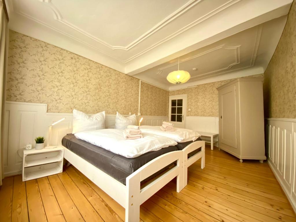 um quarto com uma grande cama branca num quarto em Ferienwohnung „Zuckerbäckerei“ em Kitzingen