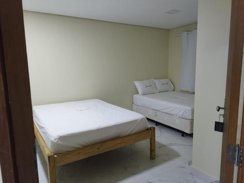 two beds in a room with white walls at LONDRES HOTEL in Gama