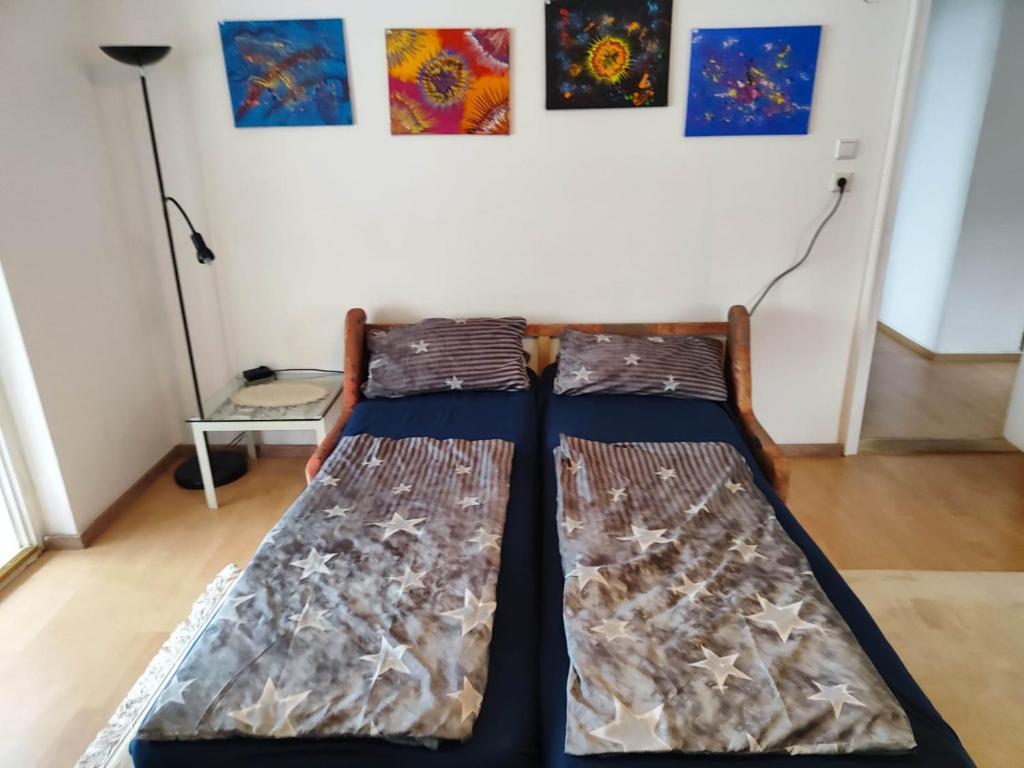 duas camas num quarto com pinturas na parede em Ferienwohnung ADAM im Haus Heidi em Höchenschwand