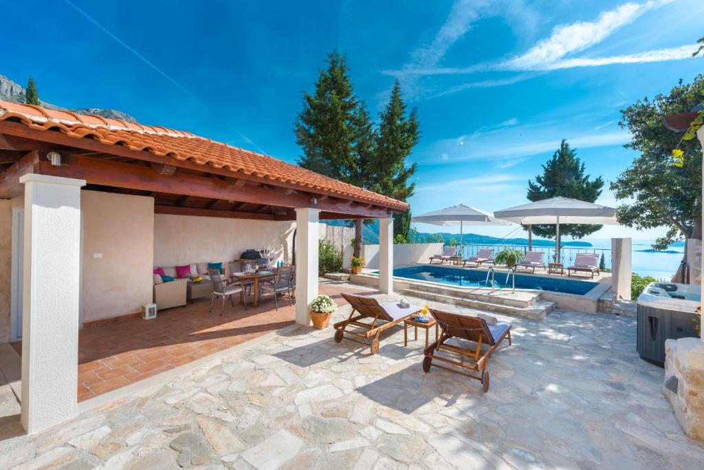 a patio with a table and chairs and a pool at Villa Tereza with Private Pool Sea View in Mlini