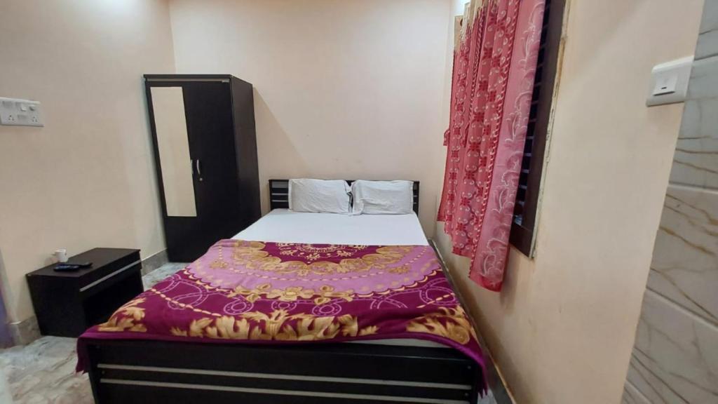 a small bedroom with a bed with a purple blanket at GRG M S M Residency Puri in Puri