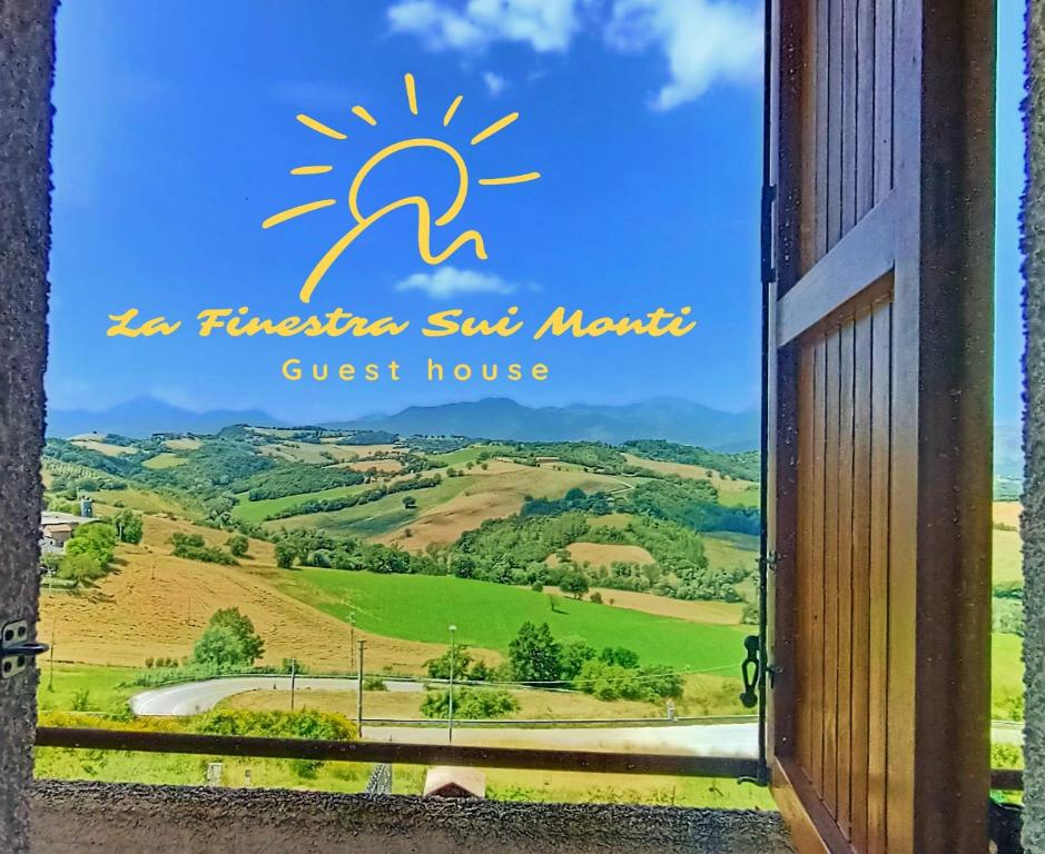 una puerta a un hostal con vistas a un campo en La Finestra Sui Monti, en Arcevia